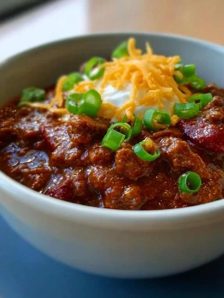 Delicious carnivore chili served in a rustic bowl with garnishes.