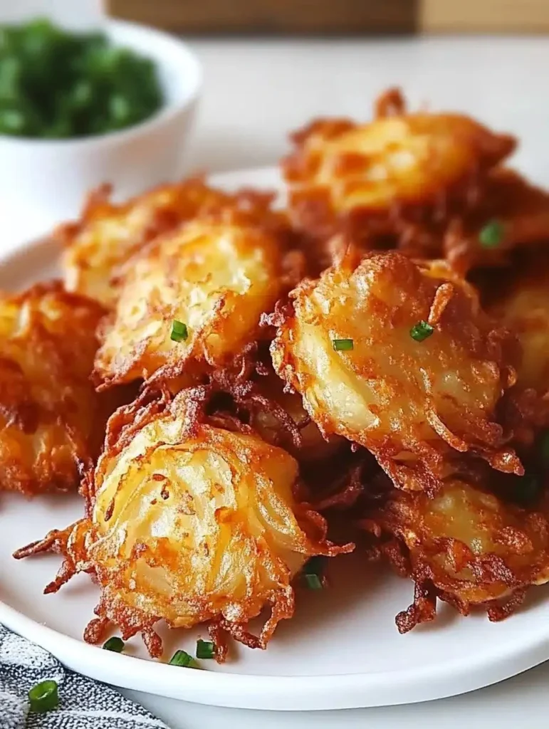 Crispy Amish onion fritters served on a plate, garnished with herbs.