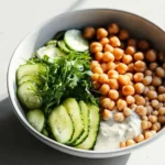 Healthy grain bowls with chickpeas and tahini dressing in a vibrant bowl