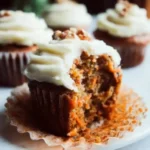 Delicious carrot cake cupcakes with cream cheese frosting on a rustic plate