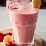 Strawberry banana smoothie in a glass with fresh fruit