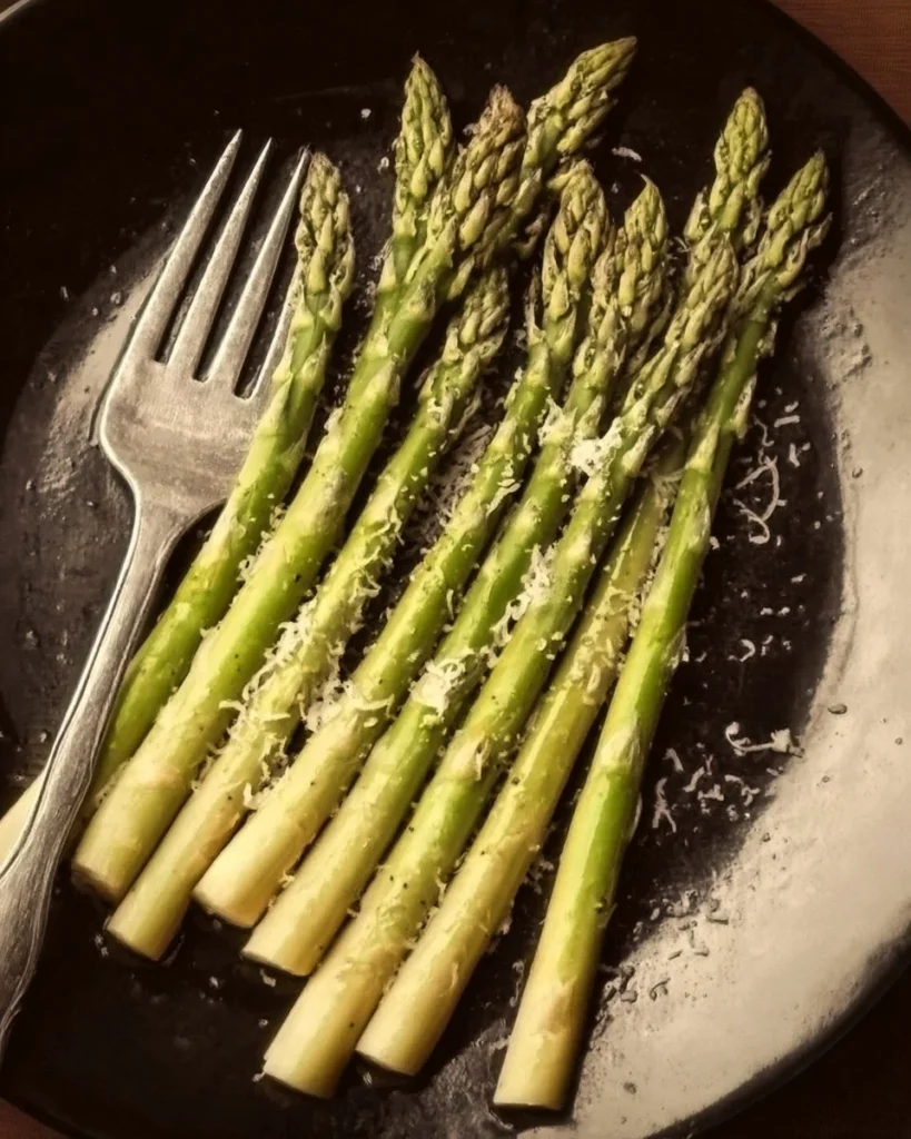 Plate of grilled asparagus topped with Asiago Cheese