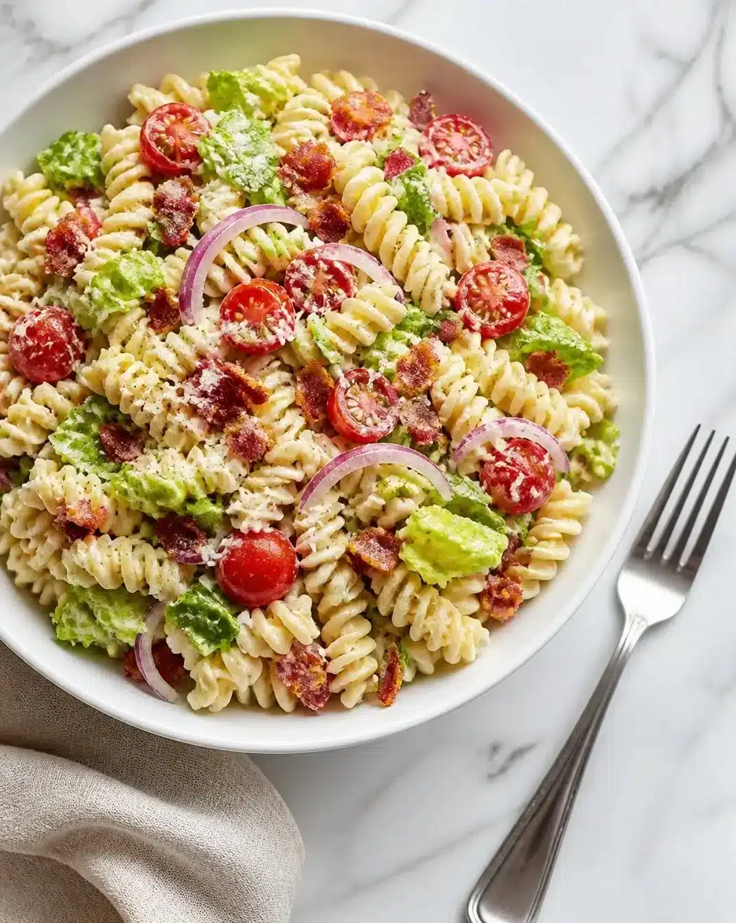 A bowl of BLT Ranch Pasta Salad with bacon, lettuce, tomatoes, and ranch dressing.