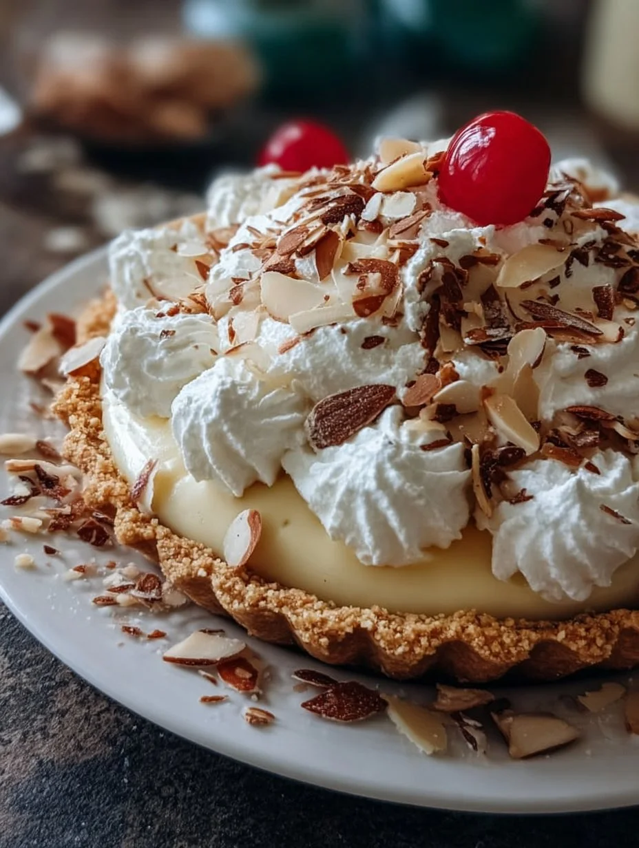 Slice of creamy Almond Amaretto Pie topped with almonds and a drizzle of amaretto syrup