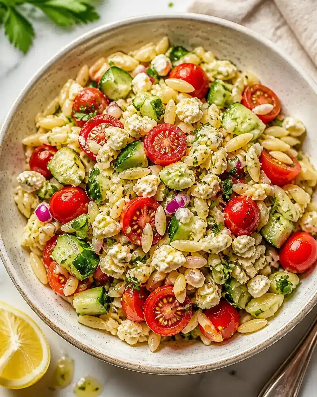 Fresh and colorful orzo salad with vegetables and dressing