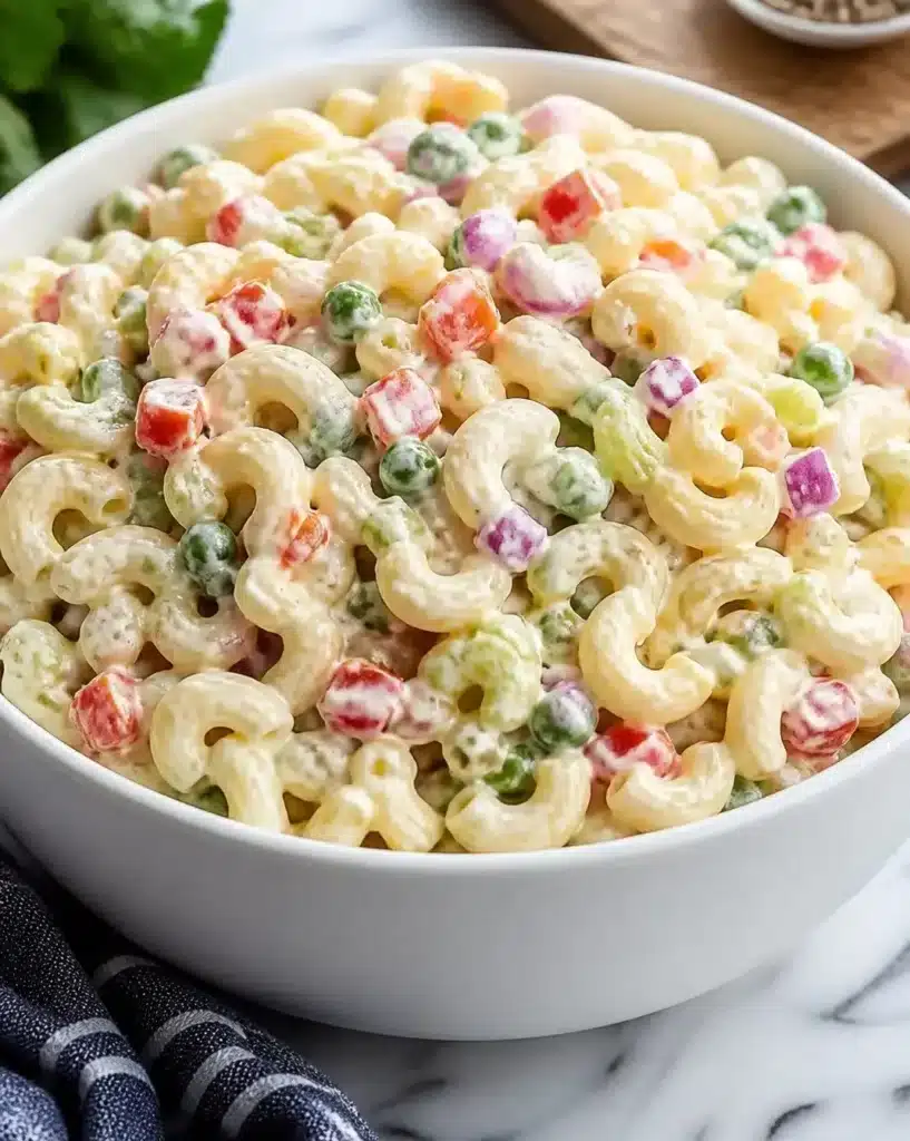A bowl of perfectly prepared macaroni salad with vegetables and dressing